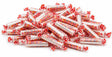 Bulk Smarties candy rolls, individually wrapped, poured out showing colorful assortment